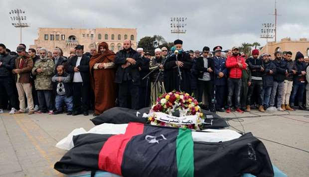Libyan people mourn during the funeral of people who were killed in an attack on a military academy in Tripoli, Libya