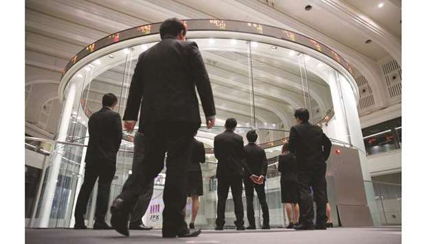 Visitors watch stock prices at the Tokyo Stock Exchange. The Nikkei 225 closed down 1.9% to 23,204.86 points yesterday.