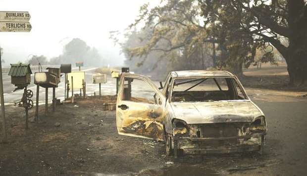 A burnt vehicle is seen on Quinlans street after an overnight bushfire in Quaama in Australiau2019s New South Wales state yesterday.