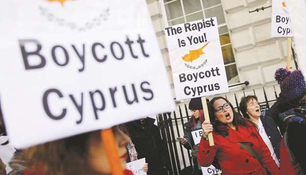 Demonstrators in London hold placards calling for a boycott on Cyprus, and in support of a British teenager convicted of lying about being raped by Israeli tourists.