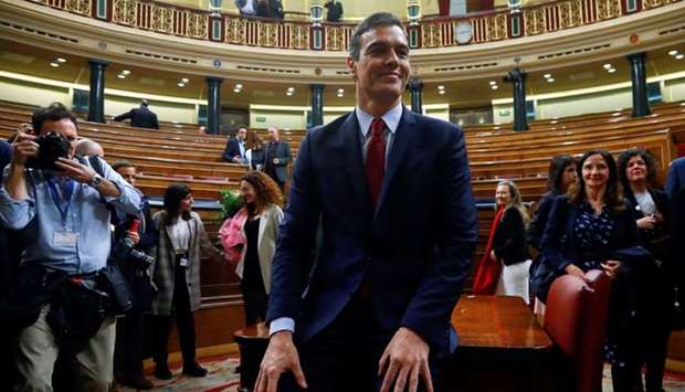 Spain's Prime Minister Pedro Sanchez poses after winning the parliamentary vote following the investiture debate at Parliament in Madrid, Spain