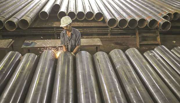 Sparks fly as a worker grinds the edge of a steel tube at the finishing line of the steel tube mill at the Steel Authority of India Rourkela Steel Plant in Odisha. Indiau2019s gross domestic product will grow 5% in the year through March 2020, the Statistics Ministry said in a statement in New Delhi yesterday.