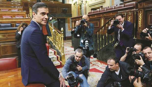 Sanchez poses after winning the parliamentary vote following the investiture debate in parliament.