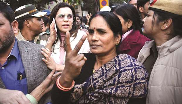 Nirbhayau2019s mother Asha Devi flashes the victory sign after a court issued death warrants against the four convicts in the rape case, outside the Patiala House Courts in New Delhi yesterday.