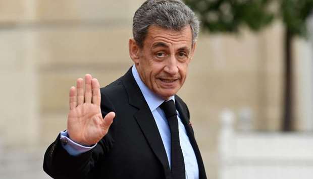 In this file photo taken on September 30, 2019 France's former President Nicolas Sarkozy waves as he leaves The Elysee Presidential Palace in Paris