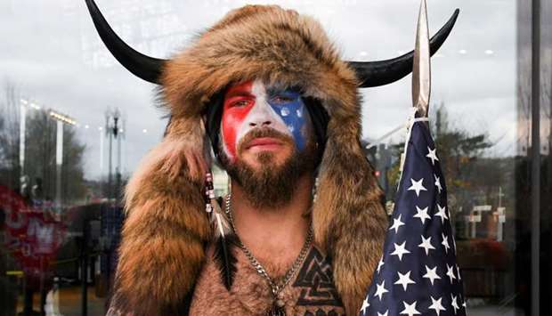 Jacob Anthony Chansley, also known as Jake Angeli, of Arizona, poses with his face painted in the colors of the US flag as supporters of US President Donald Trump gather in Washington on January 6. Reuters