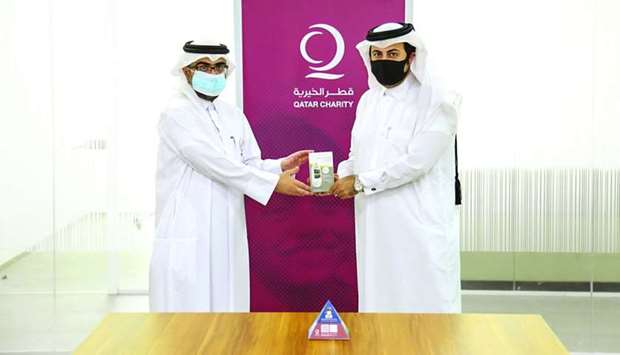 A QC official hands over a blood glucose-screening device to his QDA counterpart