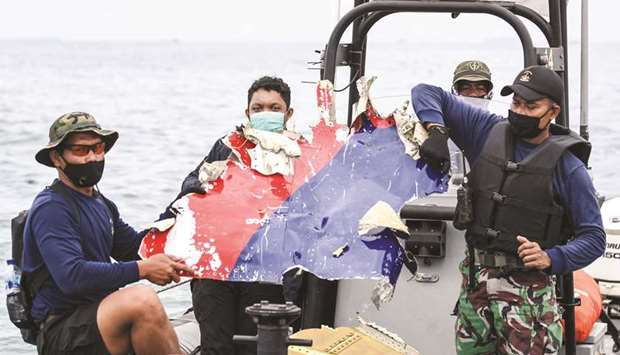 Indonesian Navy personnel carry debris believed to be from the Sriwijaya Air SJ-182 plane, which crashed into the sea, off the Jakarta coast, yesterday, in this photo taken by Antara Foto.