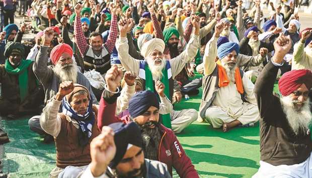 Farmers shout slogans as they sit along a blocked highway during a protest against the central governmentu2019s recent agricultural reforms at the Delhi-Uttar Pradesh state border, yesterday.