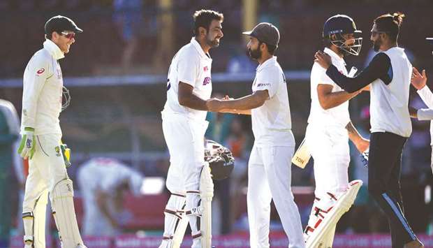 Indiau2019s captain Ajinkya Rahane (centre) along with his teammates Ravichandran Ashwin (second from left), Hanuma Vihari (second from right) and Mohammed Siraj (right) greet each other as Australiau2019s captain Tim Paine looks on at the end of the third Test at the Sydney Cricket Ground (SCG) in Sydney, Australia, yesterday. (AFP)