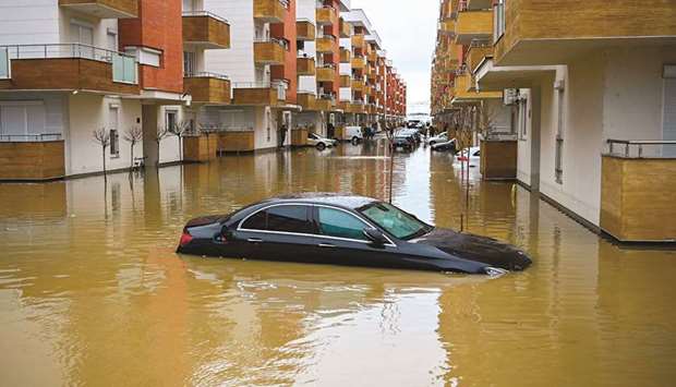 A car is seen submerged on a flooded street in the Kosovo town of Fushe Kosove after heavy rain and snow showers.