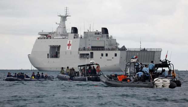 Indonesian navy divers and other rescue members stand on rubber boats next to KRI Semarang, during the search and rescue operation for the Sriwijaya Air flight SJ 182, at the sea off the Jakarta coast, Indonesia