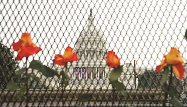 Flowers are placed in security fencing around the US Capitol days after supporters of President Donald Trump stormed the Capitol in Washington.