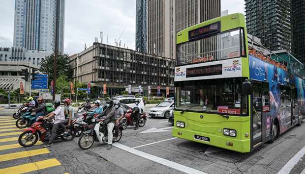 Motorists make their way on a street in Kuala Lumpur, as Malaysian authorities were set to impose tighter restrictions to try to halt the spread of the Covid-19 coronavirus.