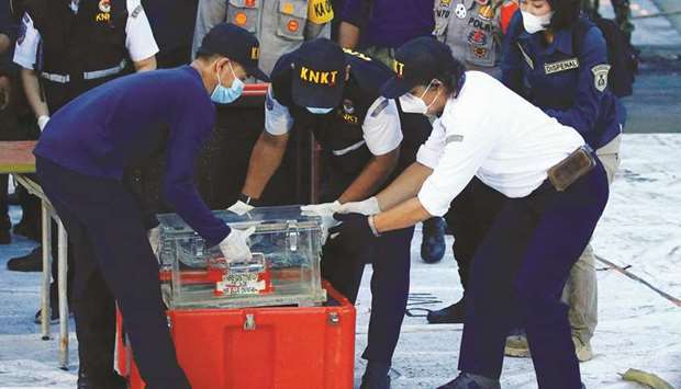 National Transportation Safety Committee (KNKT) officials hold a part of the retrieved black box of Sriwijaya Air flight SJ 182, which crashed into the sea at the weekend off the Jakarta coast.