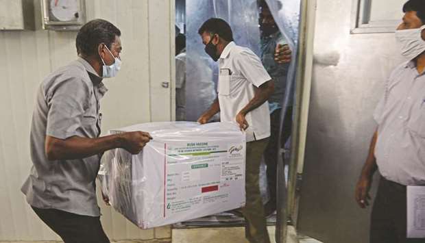Health workers carry a box of Covishield vaccine to a cold storage unit at the Regional Vaccine Storage centre in Chennai yesterday.