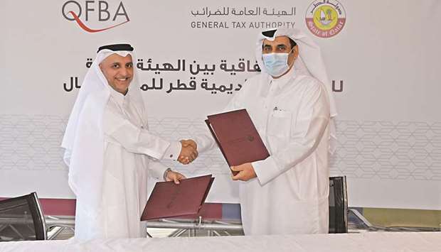 From left: QFBA CEO Dr Khalid Mohamed al-Horr and GTA president Ahmed bin Issa al-Mohannadi shaking hands after signing the partnership agreement.