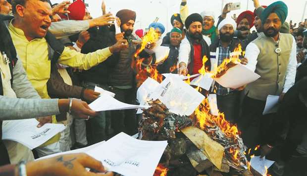 Farmers burn farm law copies in a bonfire as they celebrate the Lohri festival, at the site of a protest against the new farm laws, at the Delhi-Uttar Pradesh border in Ghaziabad, India.