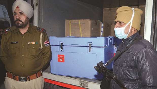 Punjab Police personnel stand near a vehicle carrying boxes of the Covishield vaccine as they reached the Regional Vaccine store in Amritsar, yesterday.