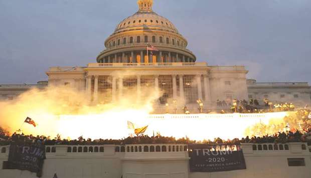 GRIM REMINDER: An explosion caused by a police munition whilst supporters of President Donald Trump gathered in front of the US Capitol Building in Washington on January 6. (Reuters)