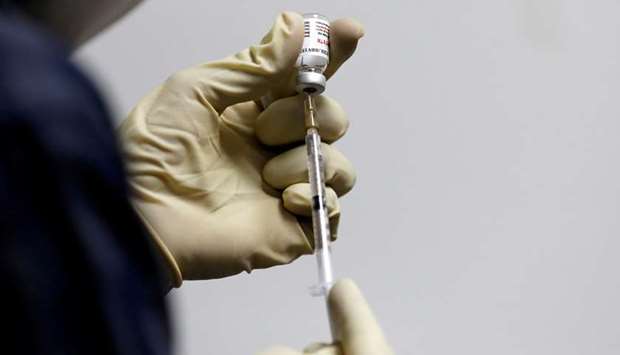 A medic fills a syringe with COVAXIN, an Indian government-backed experimental Covid-19 vaccine, before administering it to a health worker during its trials, in Ahmedabad