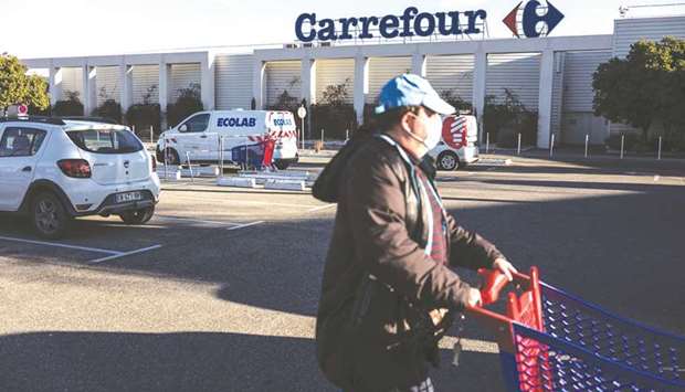 A customer wheels a shopping cart outside a Carrefour hypermarket in Avignon, France. On Wednesday, Couche-Tard submitted a non-binding offer for Carrefour valuing the group at more than u20ac16bn ($19.5bn).