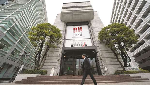 A pedestrian walks past the Tokyo Stock Exchange building. The Nikkei 225 closed 0.6% down at 28,519.18 points yesterday.