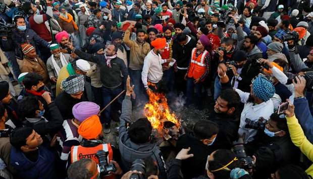 Farmers burn farm law copies in a bonfire as they celebrate the Lohri festival, at the site of a protest against the new farm laws, at the Delhi-Uttar Pradesh border in Ghaziabad, India