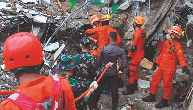 Rescuers search for survivors at a collapsed building in Mamuju in Sulawesi Island.