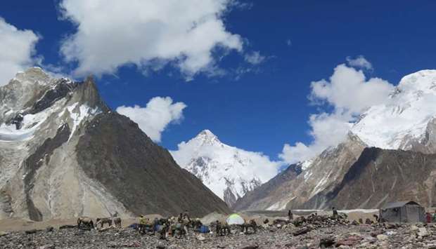 In this file photo taken on August 14, 2019, porters set up tents at the Concordia camping site in front of K2 summit (C) in the Karakoram range of Pakistan's mountain northern Gilgit region.