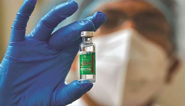 A nurse displays a vial of Covishield, AstraZenecau2019s Covid-19 vaccine made by Indiau2019s Serum Institute, as she prepares to inoculate her colleagues at KC General hospital in Bangalore.
