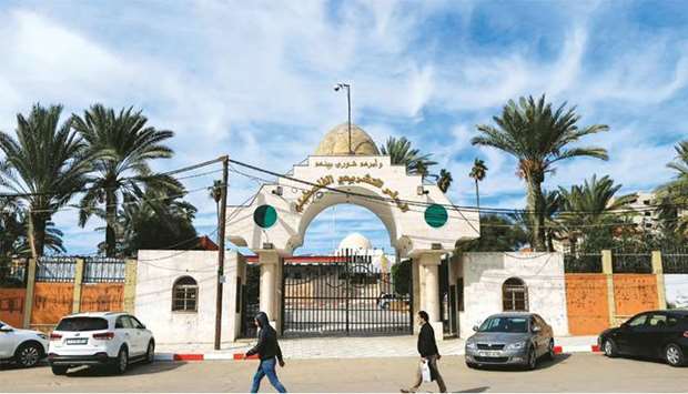 Palestinians walk past the entrance of the Legislative Council building in Gaza City, yesterday.