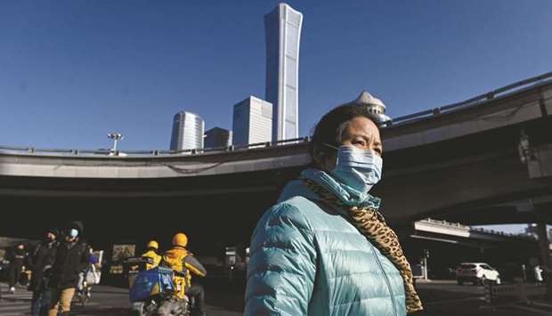 A woman crosses a street in the central business district (CBD) of Beijing on Monday. Gross domestic product grew 2.3% in 2020, official data showed on Monday, making China the only major economy in the world to avoid a contraction last year as many nations struggled to contain the Covid-19 pandemic.