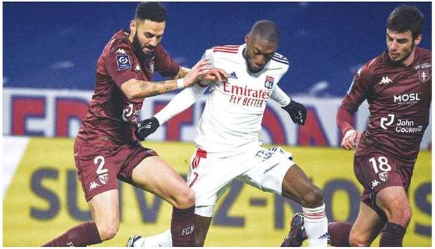 Metzu2019s Dylan Bronn (left) vies for the ball with Lyonu2019s Toko Ekambi (centre) during the French Ligue 1 match at the Groupama stadium in Decines-Charpieu, near Lyon, on Sunday. (AFP)