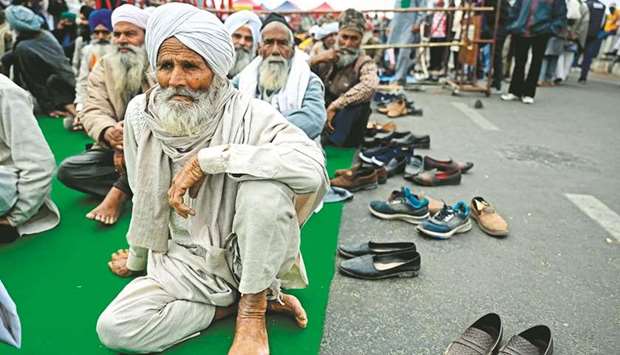 Farmers sit along a blocked highway as they continue to protest against the governmentu2019s recent agricultural reforms at the Delhi-Uttar Pradesh state border in Ghazipur yesterday.