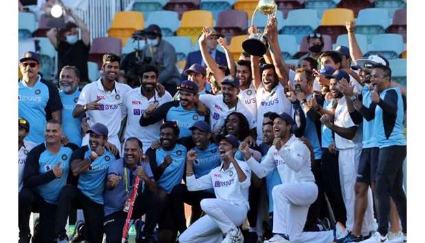 India's players and officials celebrate with the winning trophy at the end of the fourth cricket Test match between Australia and India at The Gabba in Brisbane