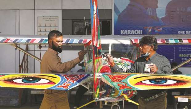 Haider Ali and his student paint Pakistani truck art on a two-seater Cessna at general  aviation area at Jinnah International Airport in Karachi.