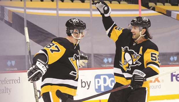 Pittsburgh Penguins center Sidney Crosby (left) celebrates his game winning goal in overtime with defenseman Kris Letang against the Washington Capitals at PPG Paints Arena in Pittsburgh, Pennsylvania. (USA TODAY Sports)