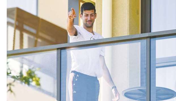 World number one Novak Djokovic of Serbia gestures from his hotel balcony in Adelaide. (AFP)