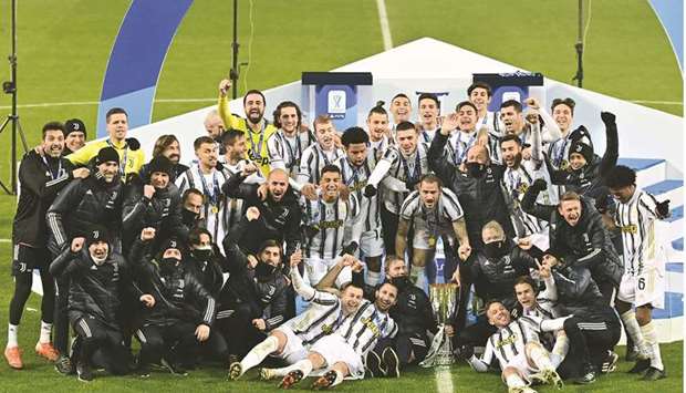 Juventusu2019 players and staff celebrate with the trophy after winning the Italian Super Cup at the Mapei stadium in Reggio Emilia, Italy. (AFP)