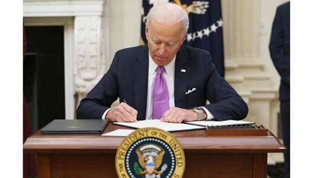 US President Joe Biden signs executive orders as part of the Covid-19 response in the State Dining R