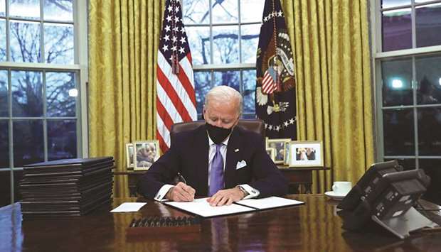 FIRST ORDER OF BUSINESS: President Biden signing executive orders in the Oval Office of the White House, after his inauguration as the 46th President of the United States.