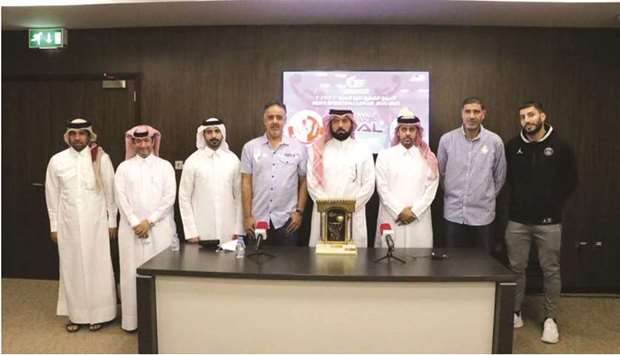 Al Shamal and Al Gharafa coaches pose with the QBF officials and Qatar Menu2019s Basketball League trophy yesterday.