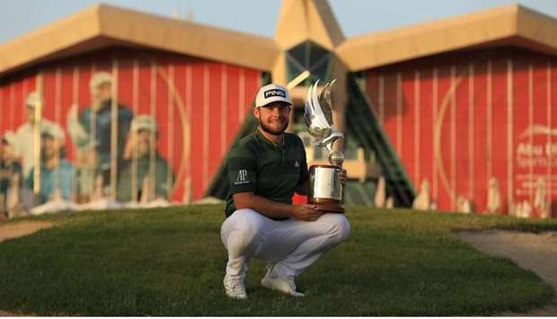 Tyrrell Hatton poses with his trophy after his victory in Abu Dhabi yesterday.