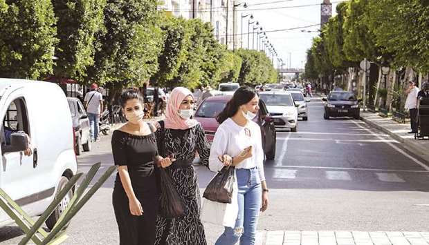 Mask-clad women cross the Avenue Habib Bourguiba in the centre of Tunisiau2019s capital Tunis (file). u201cTunisia faces two immediate challenges: saving lives and livelihoods until the pandemic wanes, and starting to bring economic imbalances back to a sustainable trajectory,u201d according to the IMF.