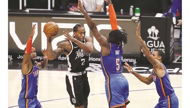 Kawhi Leonard of the Los Angeles Clippers looks to pass the ball while defended by Luguentz Dort (second right), Shai Gilgeous-Alexander (left) and George Hill of the Oklahoma City Thunder during the fourth quarter at Staples Center in Los Angeles, California. (Getty Images/AFP)