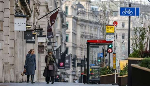 Two women walk down Regent Street, one of London's main shopping streets in Britain