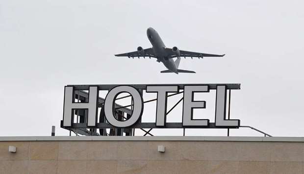 An airplane is seen flying over a hotel at Heathrow Airport in west London