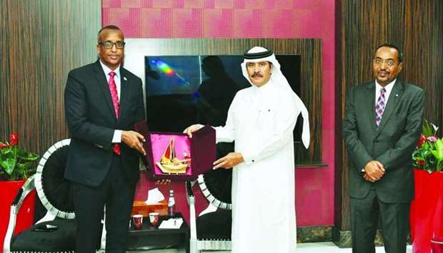 Qatar Chamberu2019s second vice chairman Rashid bin Hamad al-Athba hands over a token of recognition to Somalia Minister for Labour Durran Ahmed Farah during a visit to the chamber's headquarters.