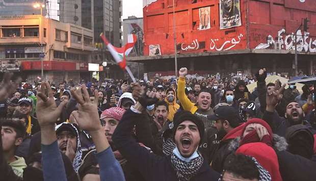 Lebanese protesters shout slogans as they gather at Al-Nour Square during ongoing demonstrations in the northern port city of Tripoli, yesterday, as anger grows over a total lockdown aimed at stemming an unprecedented spike in coronavirus cases.